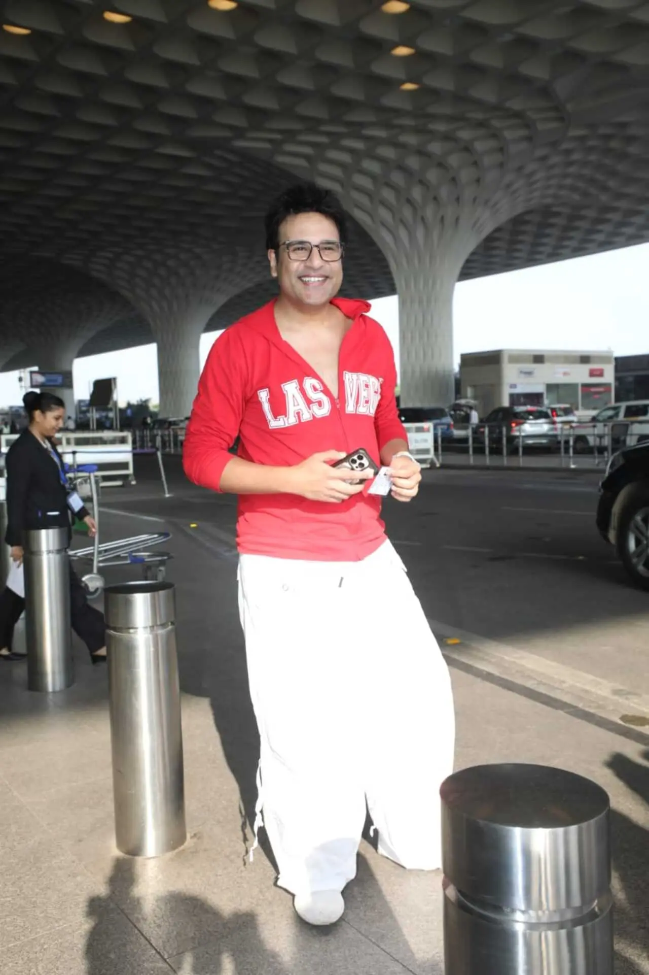 Comedian and actor Krushna Abhishek was spotted at the airport as he headed out of the city in a red hoodie and white loose pants.